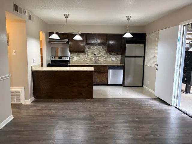 a view of kitchen with refrigerator and microwave