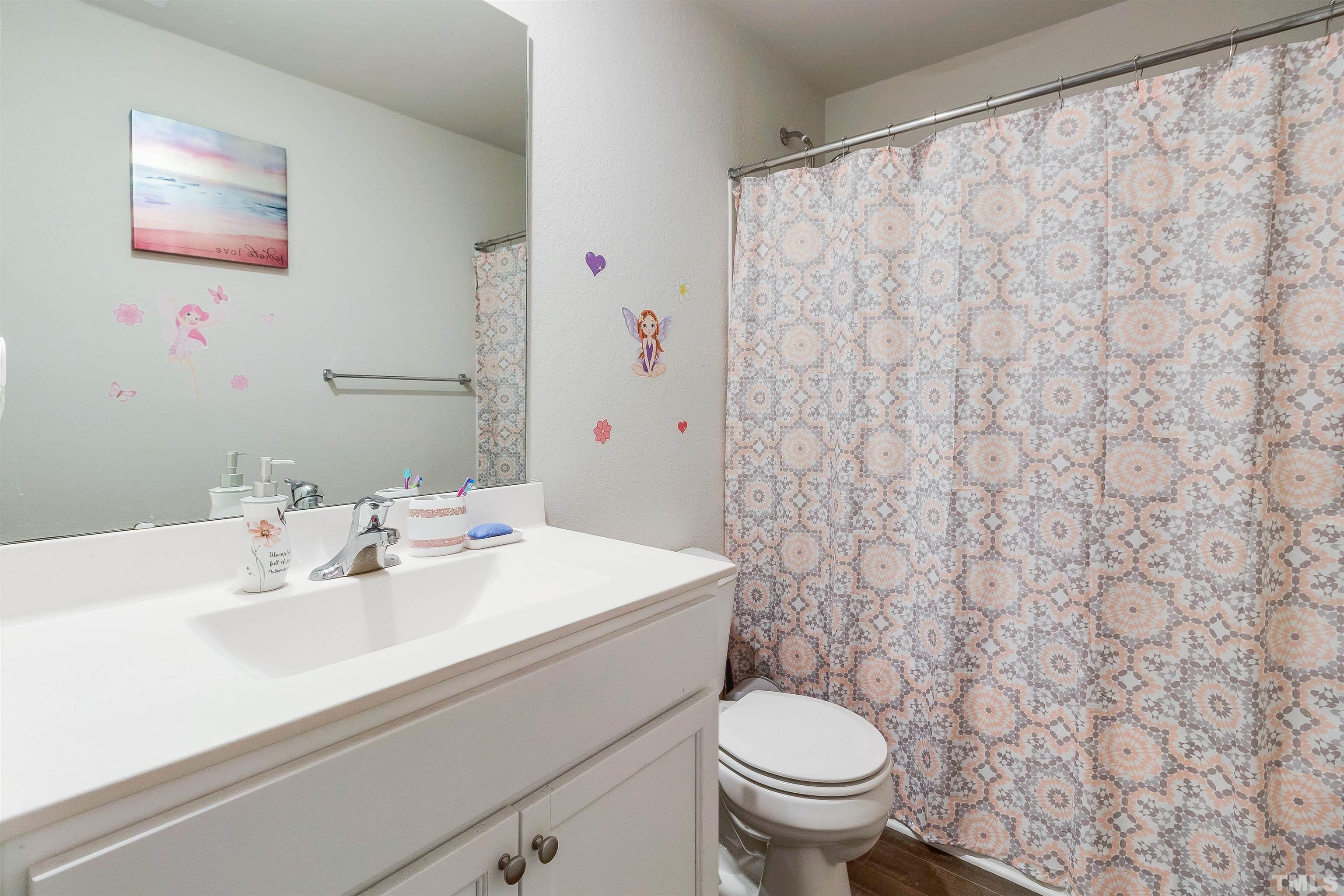 232 Rustling Way Zebulon, NC 27597 - Photo 10 of 14 a bathroom with a sink a toilet and a mirror