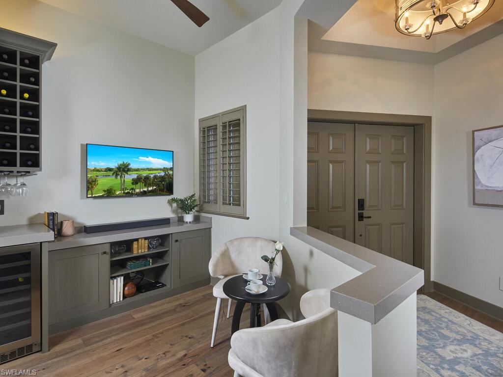 7655 Pebble Creek Circle, Unit 404 Naples, FL 34108 - Photo 8 of 19 a living room with furniture and a flat screen tv