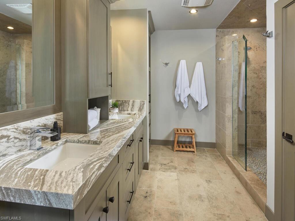7655 Pebble Creek Circle, Unit 404 Naples, FL 34108 - Photo 10 of 19 a bathroom with a double vanity sink mirror and shower