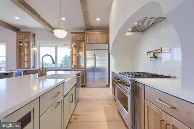 a large kitchen with a large counter top sink and stainless steel appliances