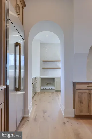 a view of a big room with wooden floor and a kitchen