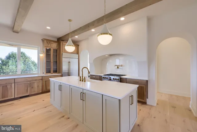 a large kitchen with a lot of counter space and wooden floor