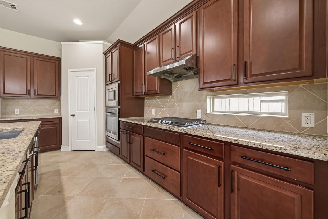 107 Angel Hollow Lane Rosenberg, TX 77469 - Photo 3 of 50 The kitchen feels incredibly high-end, featuring glossy countertops and a clever "window backsplash" that lets in natural light while you prepare your favorite meals.