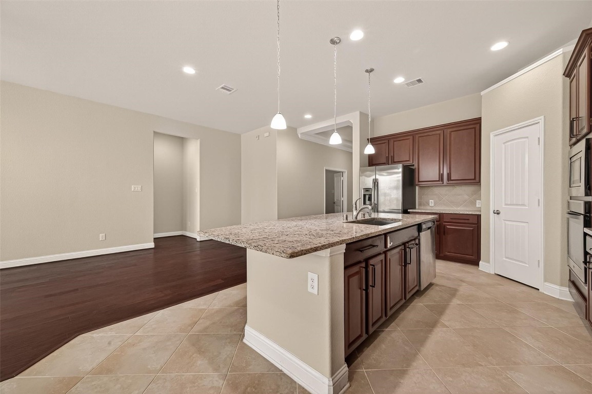 107 Angel Hollow Lane Rosenberg, TX 77469 - Photo 9 of 50 This substantial center island under pendant lighting is a natural gathering spot for a glass of wine and good conversation.
