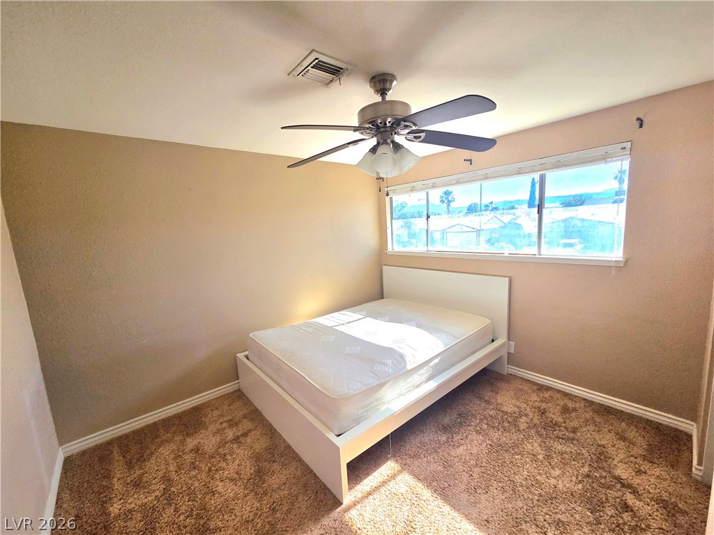 3648 Bronco Road Las Vegas, NV 89103 - Photo 23 of 24 Well-lit bedroom with soft carpet flooring and a wide window offering serene views.