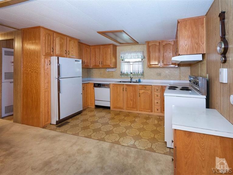 2400 East Pleasant Valley Road, Unit 136 Oxnard, CA 93033 - Photo 2 of 16 a kitchen with stainless steel appliances granite countertop a refrigerator sink and cabinets