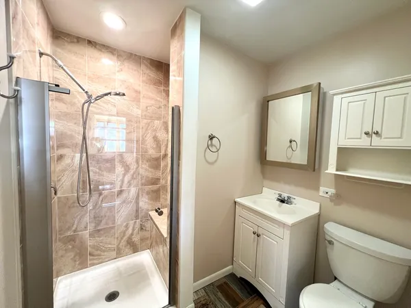 a bathroom with a granite countertop sink toilet and shower