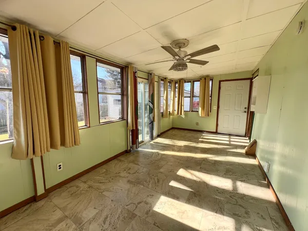 a view of an empty room with a fireplace and a window