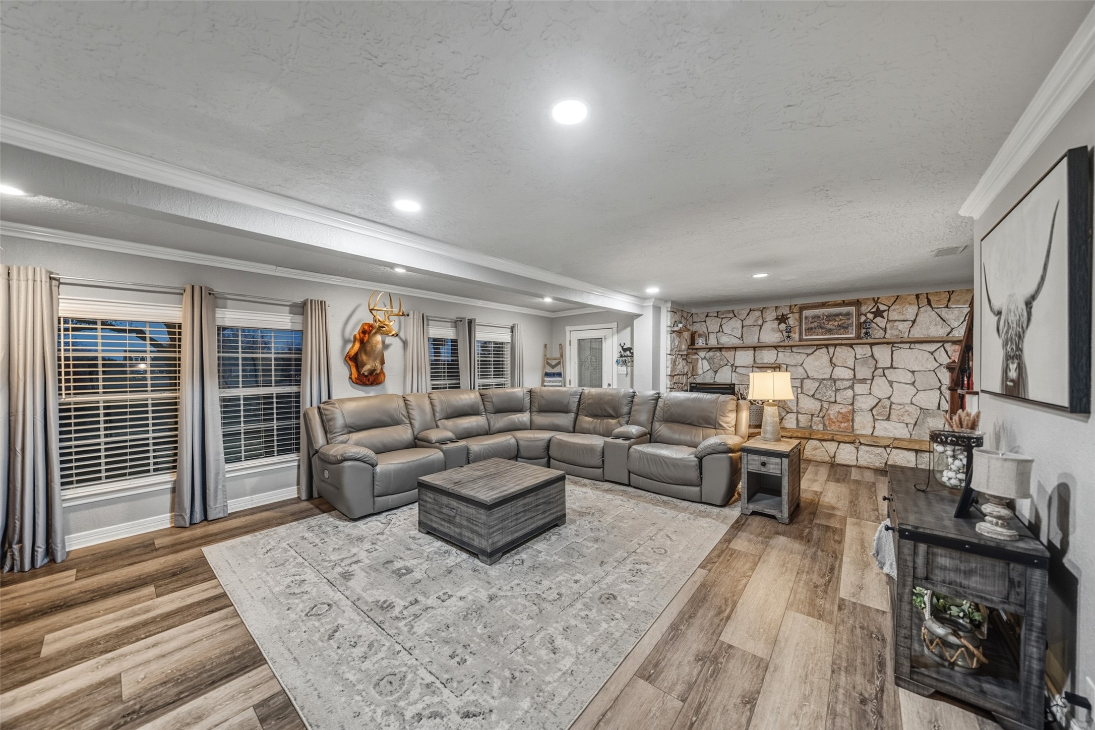 19989 Meadow Bend Road Hempstead, TX 77445 - Photo 18 of 35 Well-sized living room features large windows for natural light and a stone fireplace backdrop that adds warmth and character.