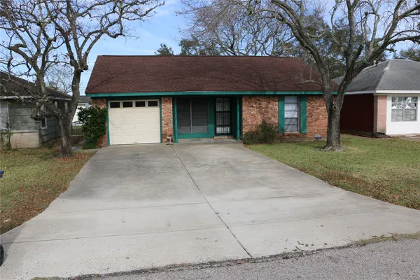a front view of a house with a garden and trees