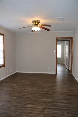 a view of empty room with wooden floor