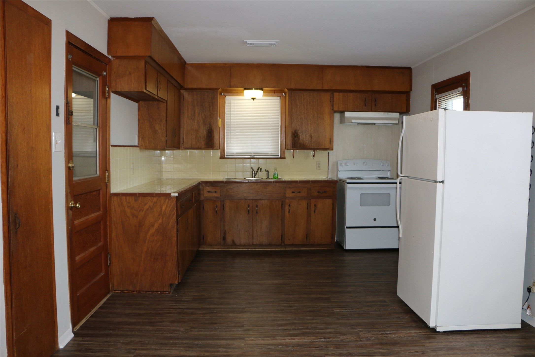 710 West 7th Street Freeport, TX 77541 - Photo 19 of 20 a kitchen with a refrigerator a sink and cabinets