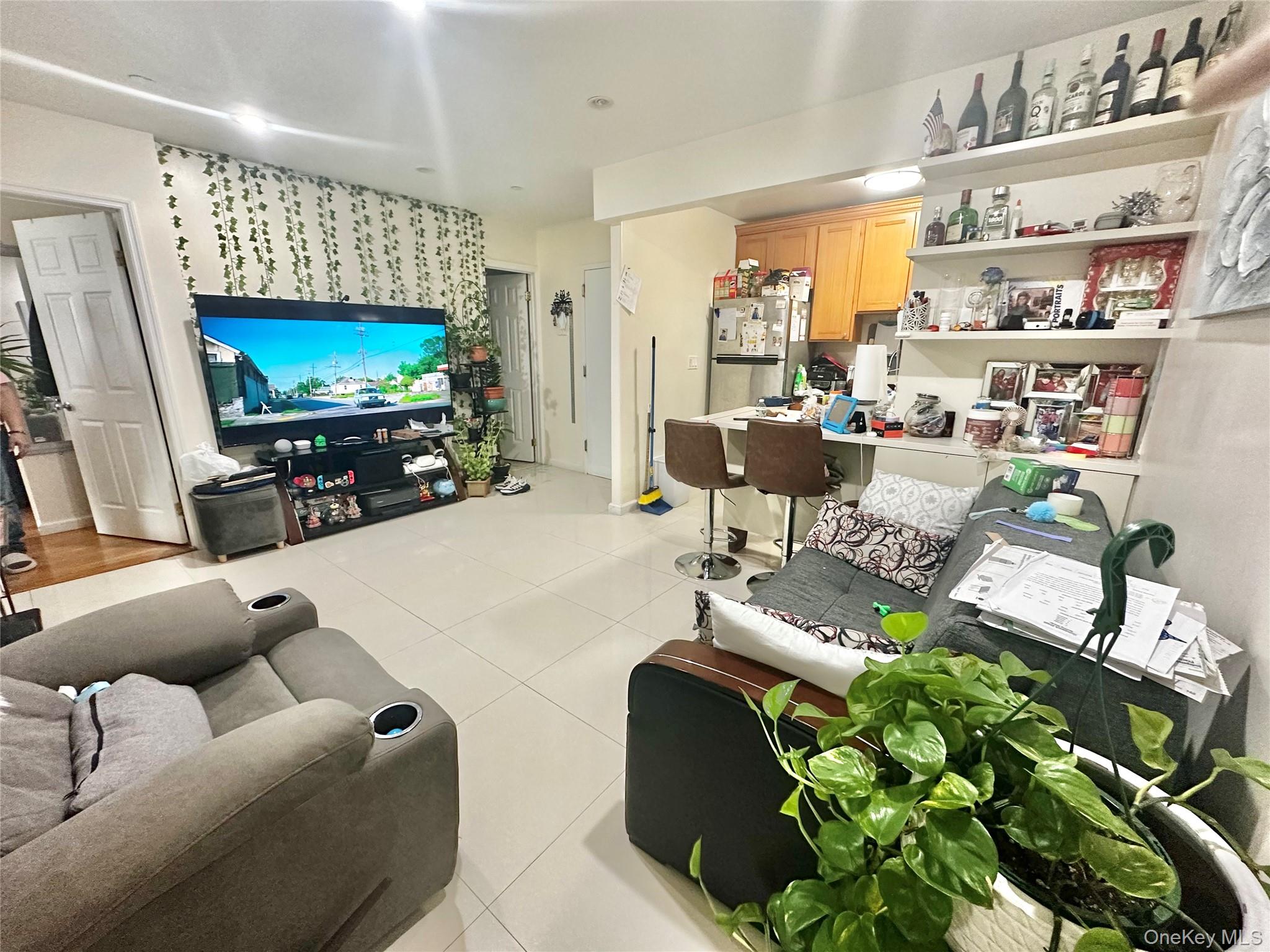 104-48 37th Drive, Unit 3A Queens, NY 11368 - Photo 3 of 17 a living room with furniture a flat screen tv and a fireplace