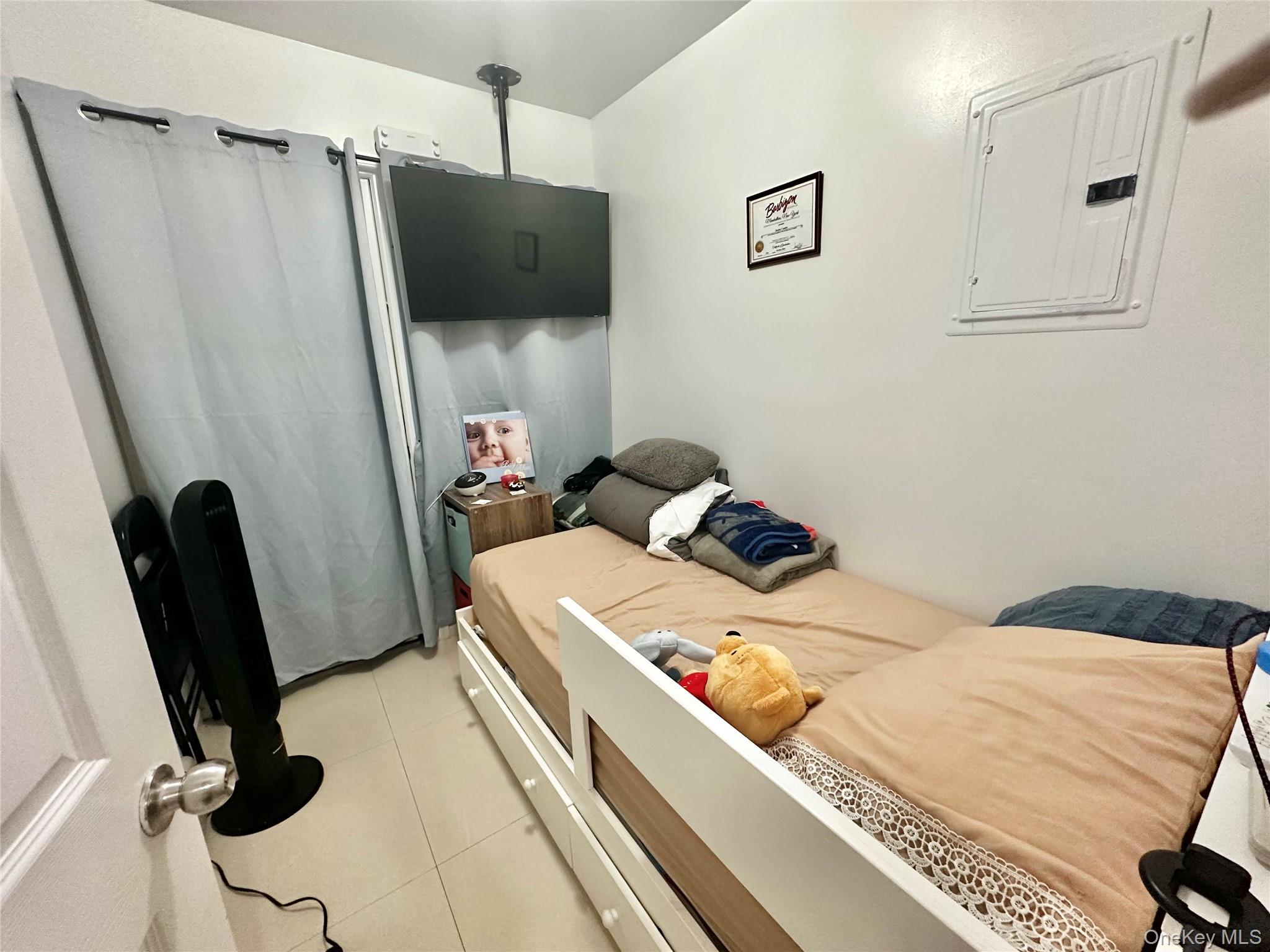 104-48 37th Drive, Unit 3A Queens, NY 11368 - Photo 4 of 17 a bedroom with a bed and a mirror