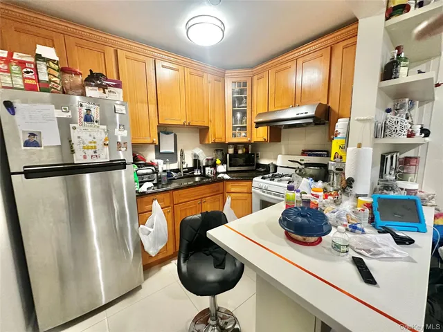 a kitchen with stainless steel appliances a refrigerator a sink a stove and a cabinets
