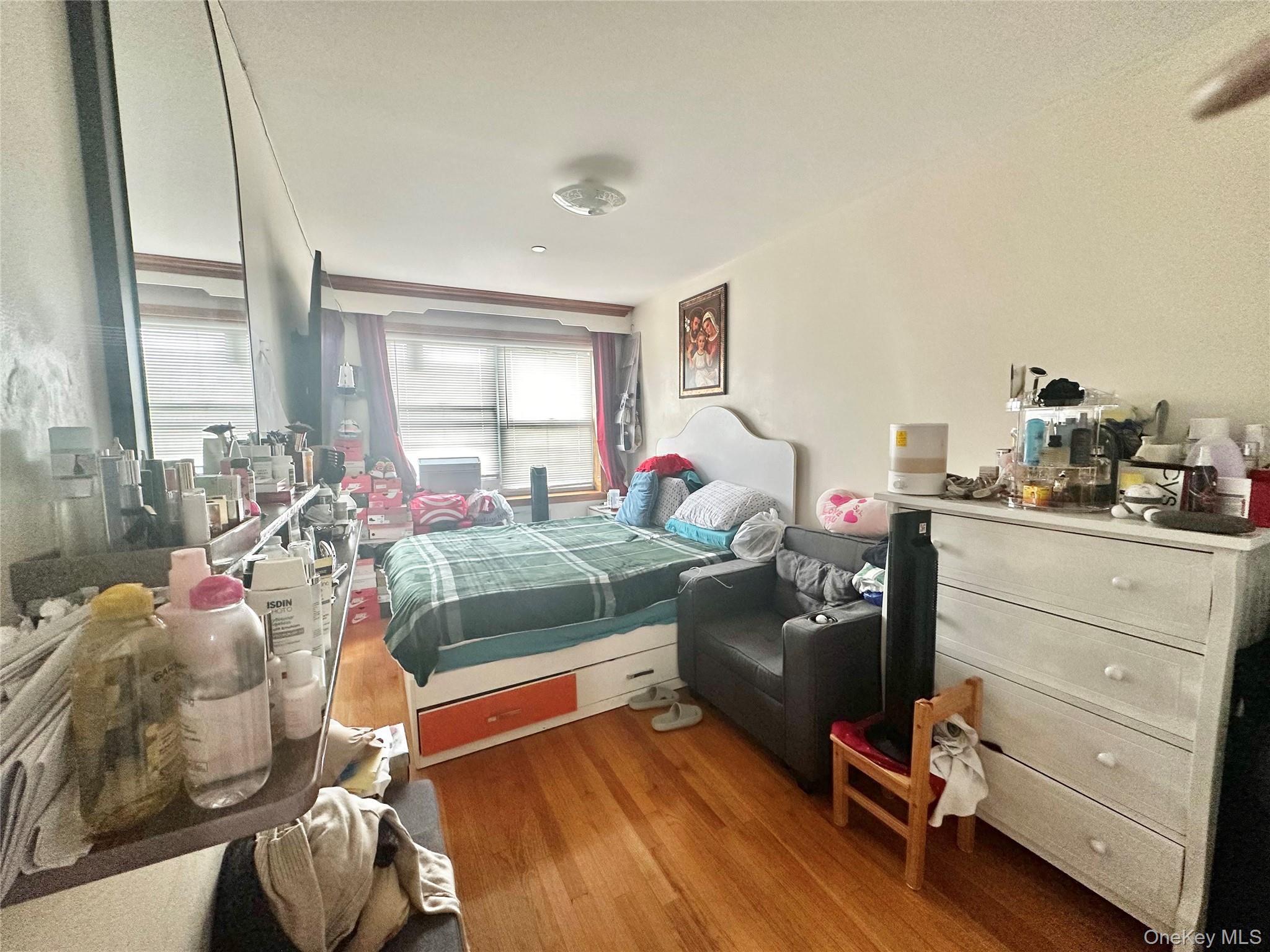 104-48 37th Drive, Unit 3A Queens, NY 11368 - Photo 6 of 17 a bedroom with a bed and wooden floor