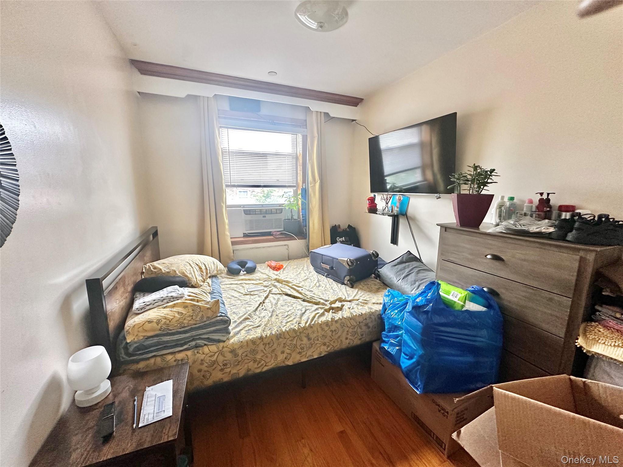 104-48 37th Drive, Unit 3A Queens, NY 11368 - Photo 7 of 17 a bed room with a bed and a chair