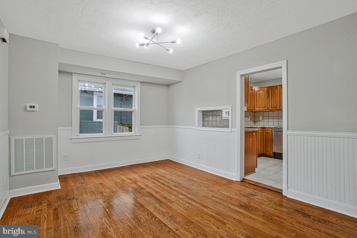 119 West Edgevale Road Baltimore, MD 21225 - Photo 14 of 37 a view of an empty room with wooden floor and a window
