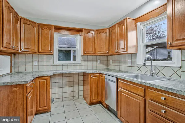 a kitchen with granite countertop a sink dishwasher stove and cabinets