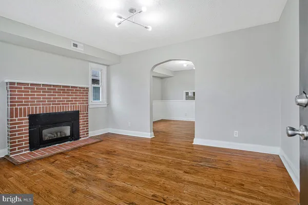 a view of empty room with wooden floor and fireplace