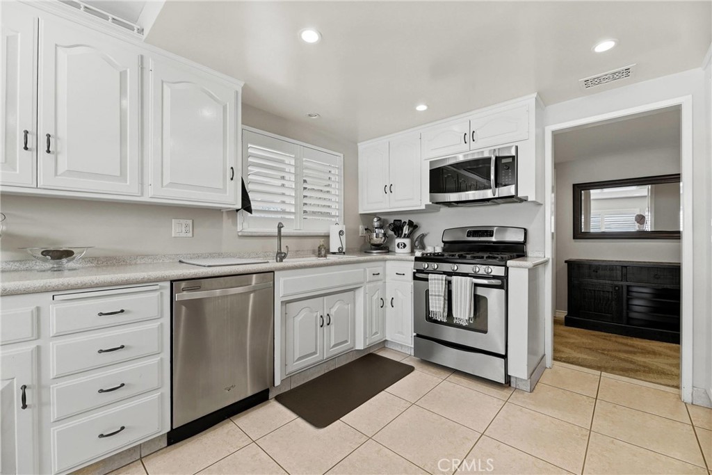 930 La Rue Avenue, Unit RUE La Verne, CA 91750 - Photo 15 of 63 a kitchen with granite countertop white cabinets stainless steel appliances and sink