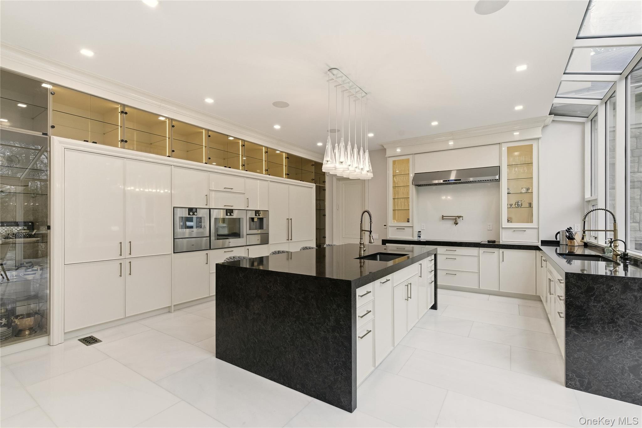 55 Coves Run Syosset, NY 11791 - Photo 14 of 50 a large white kitchen with a large counter top stainless steel appliances and cabinets