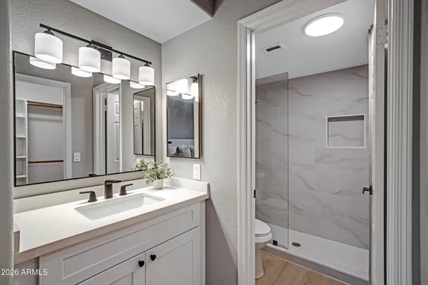 a bathroom with a shower sink vanity granite and mirror