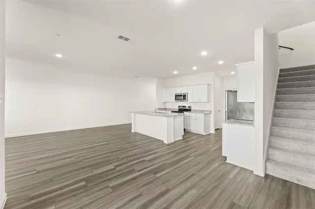 a view of kitchen with wooden floor and electronic appliances