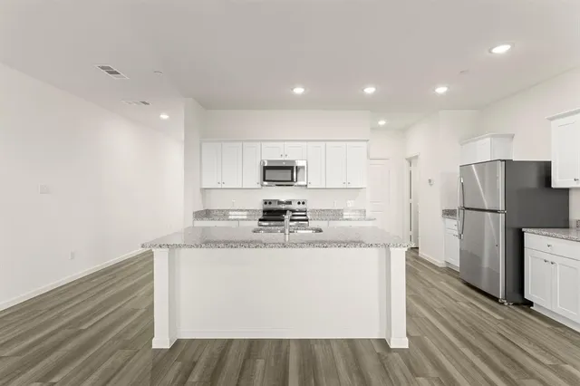 a kitchen with stainless steel appliances granite countertop a sink stove and refrigerator