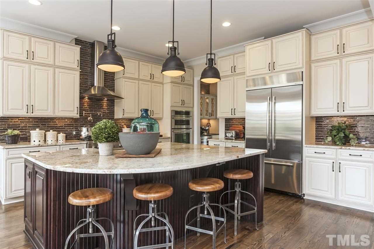 3623 Rolston Drive, Unit 9 Raleigh, NC 27609 - Photo 8 of 25 a kitchen with stainless steel appliances granite countertop a table chairs stove and white cabinets