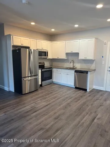 a kitchen with stainless steel appliances granite countertop a refrigerator sink and cabinets