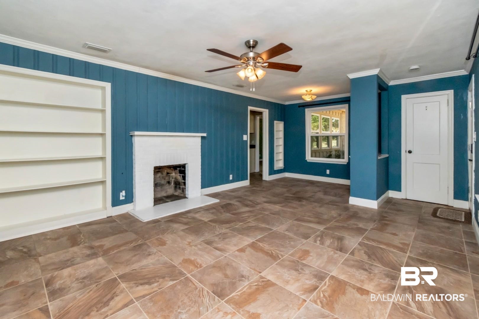 410 St John Place Mobile, AL 36609 - Photo 4 of 32 Unfurnished living room with built in shelves, a ceiling fan, a fireplace, and ornamental molding