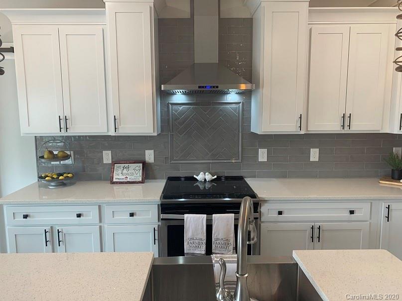 545 Gatton Road Cleveland, NC 27013 - Photo 10 of 27 a kitchen with stainless steel appliances granite countertop a stove a sink and white cabinets
