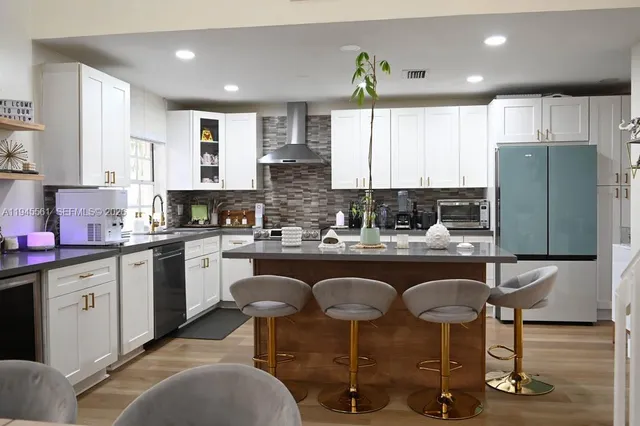 a kitchen with stainless steel appliances granite countertop a sink a stove and a wooden floors