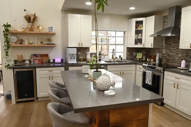 a kitchen with kitchen island granite countertop a sink cabinets and stainless steel appliances