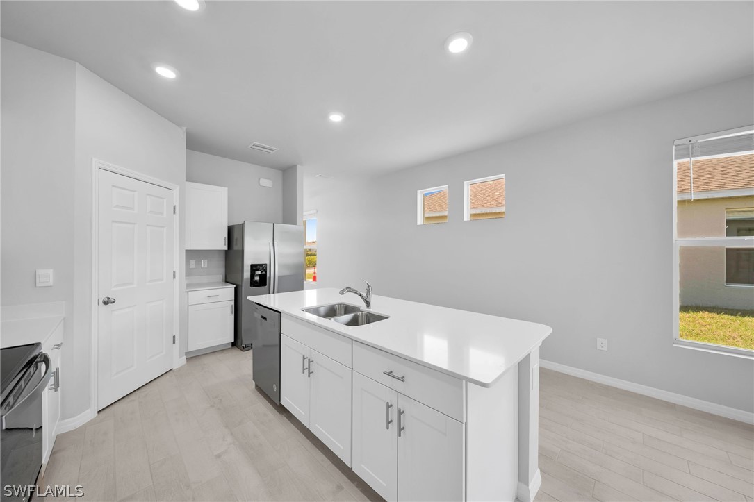 900 Friendship Circle LaBelle, FL 33935 - Photo 7 of 21 a kitchen with white cabinets and sink