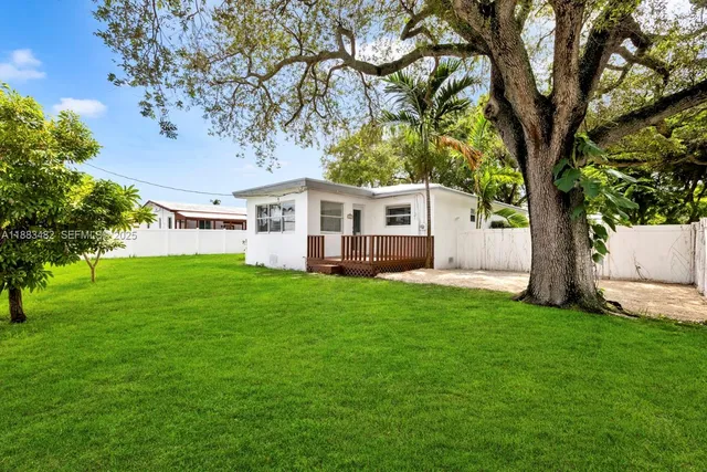 a view of a house with backyard and a tree