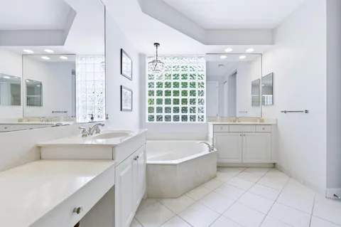 a bathroom with a bathtub a sink and a large mirror