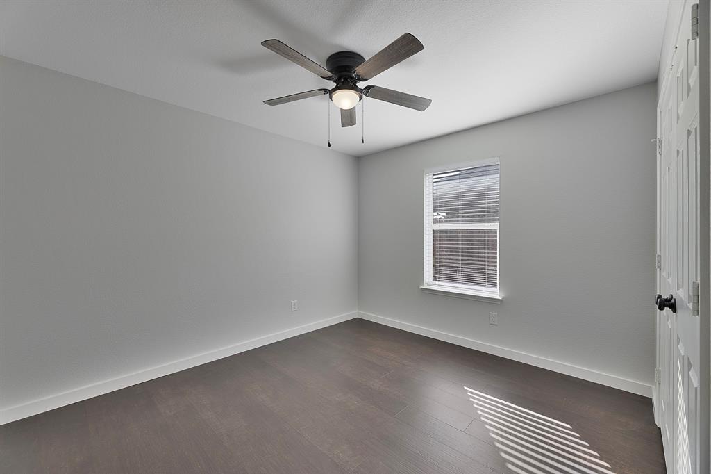 605 Clearbrook Street Azle, TX 76020 - Photo 25 of 33 Room with light gray walls, wood-finish flooring, a ceiling fan with integrated lighting, and a window with blinds