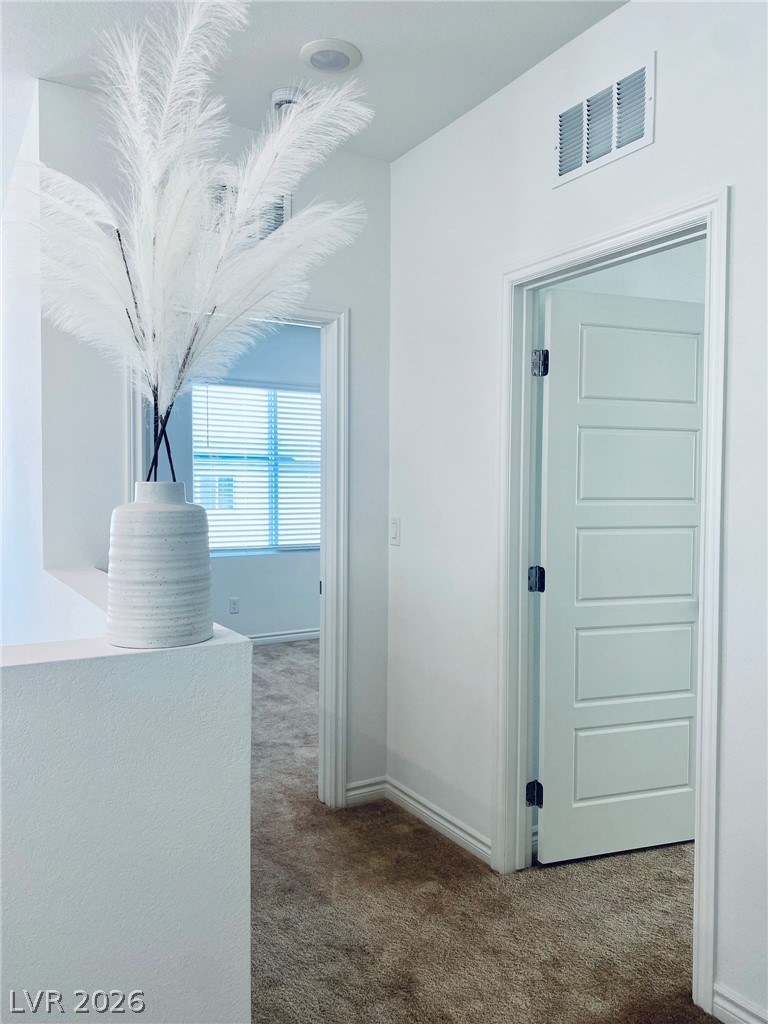 4457 Sawyer Ridge Street Las Vegas, NV 89147 - Photo 20 of 32 This interior hallway offers plush carpeting, clean white walls, and bright natural light.