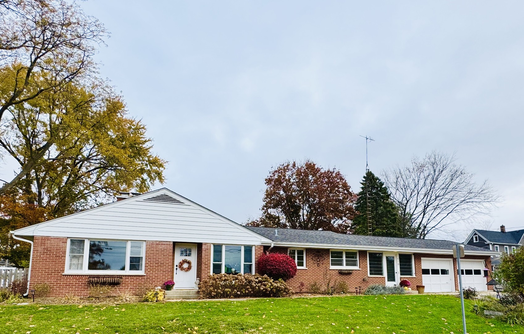 a front view of a house with a garden and trees