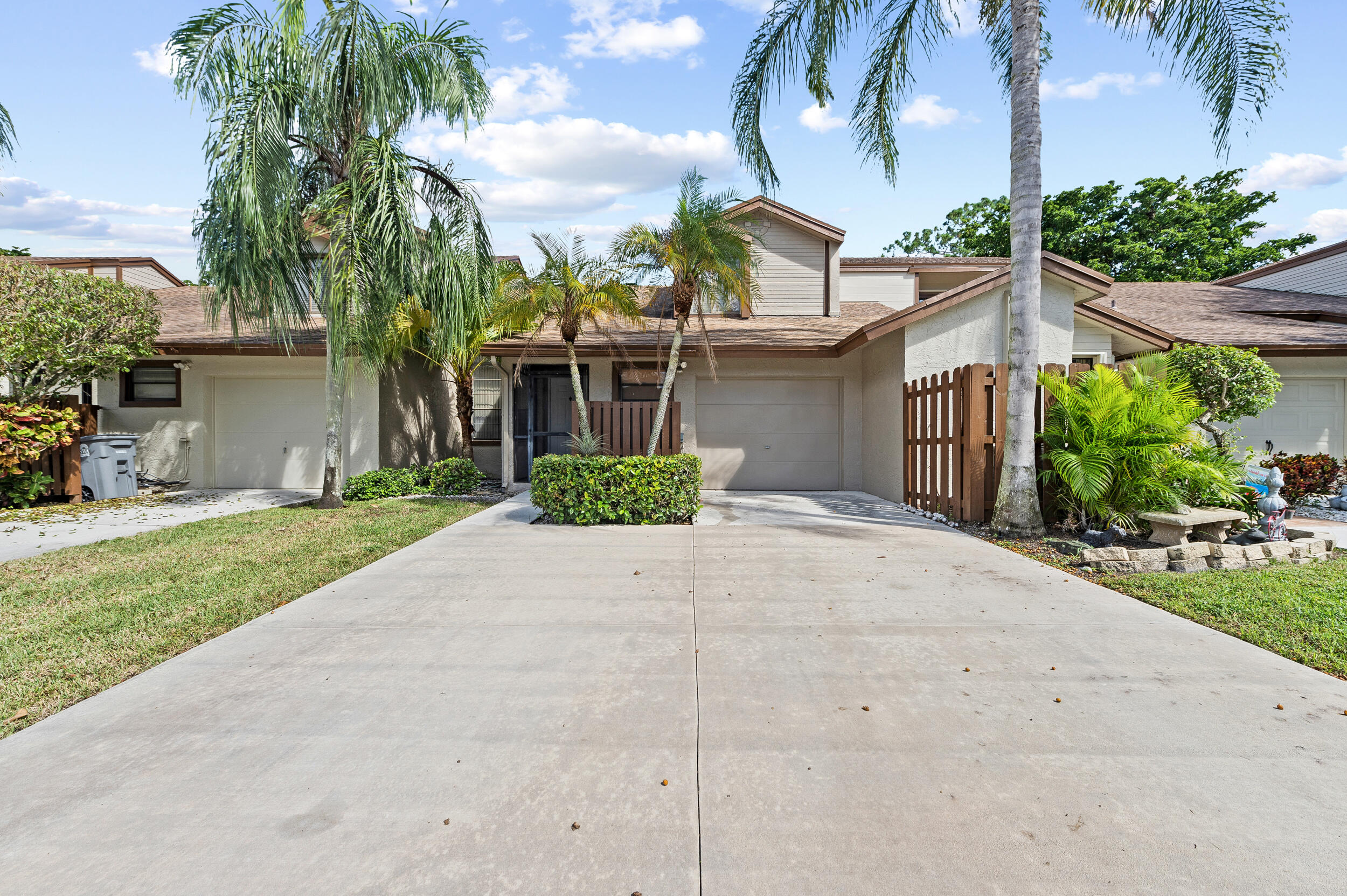22384 Thousand Pines Lane Boca Raton, FL 33428 - Photo 11 of 45 a front view of a house with a yard and potted plants
