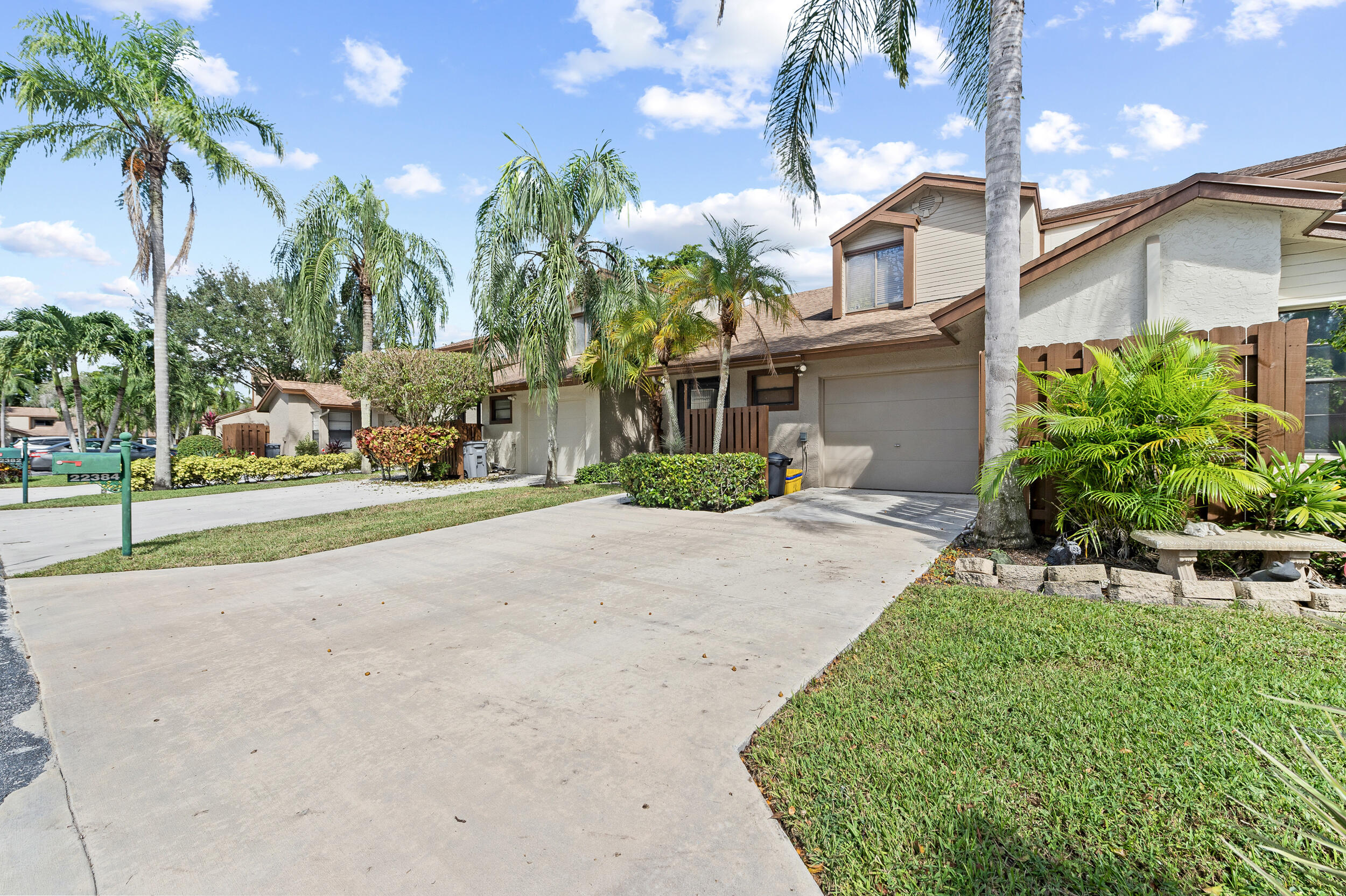 22384 Thousand Pines Lane Boca Raton, FL 33428 - Photo 12 of 45 a front view of a house with a yard and potted plants