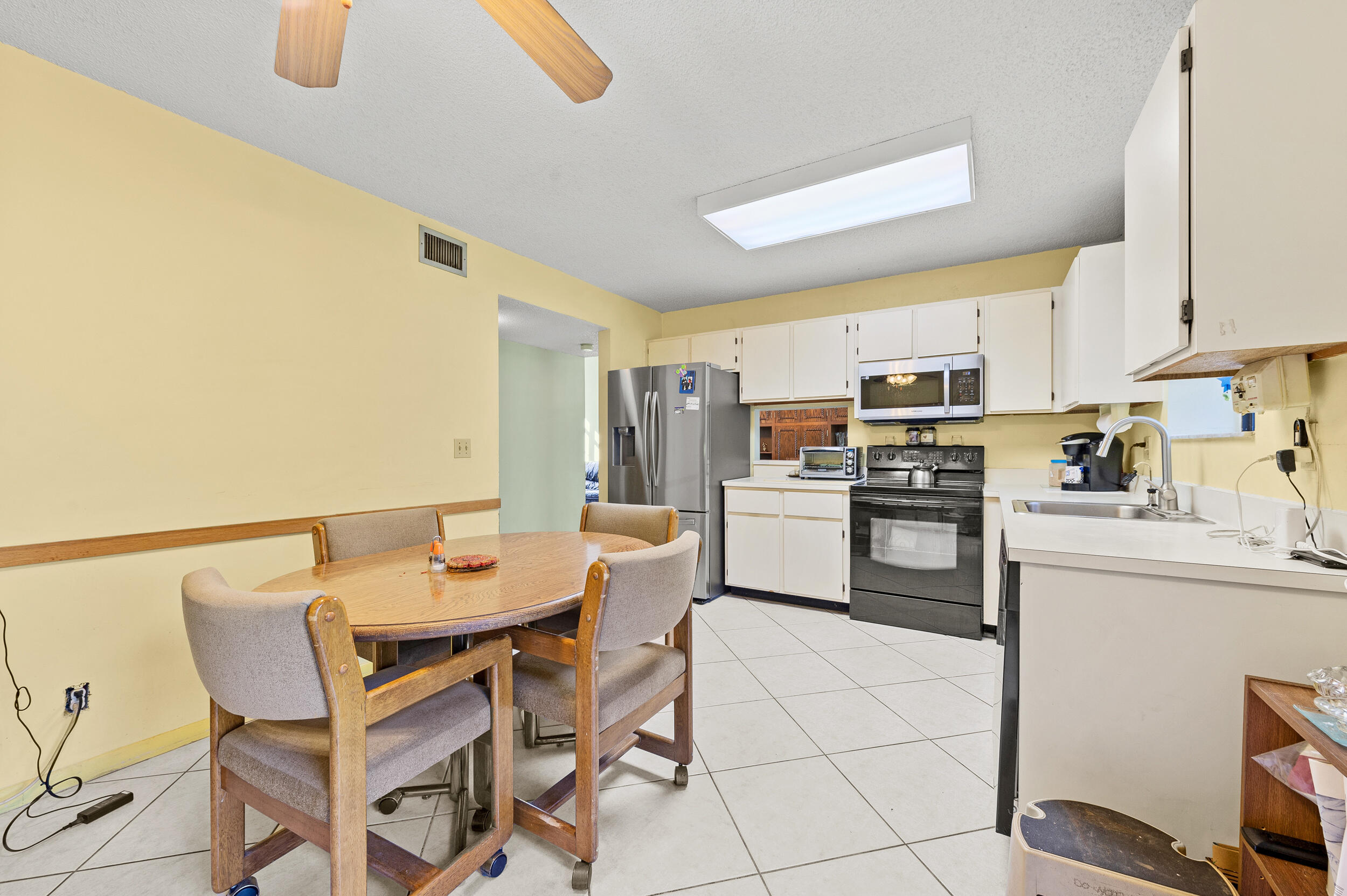 22384 Thousand Pines Lane Boca Raton, FL 33428 - Photo 24 of 45 a kitchen with a dining table chairs appliances and cabinets