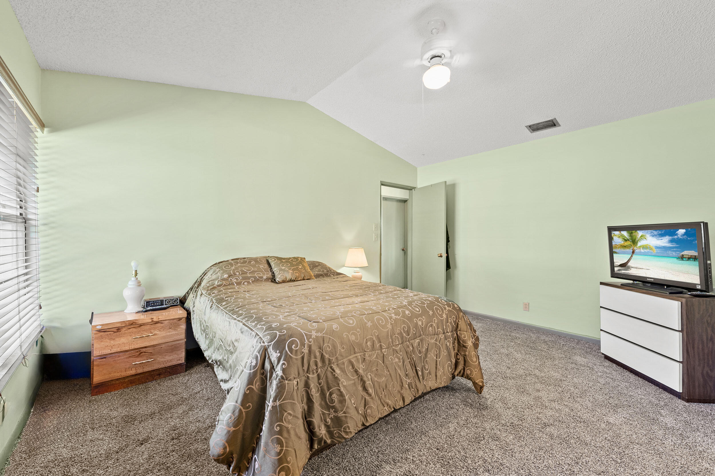 22384 Thousand Pines Lane Boca Raton, FL 33428 - Photo 33 of 45 a bedroom with a bed and a tv on the dresser