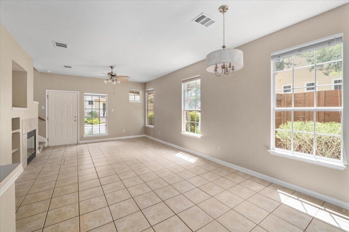 11000 Anderson Mill Road, Unit 11 Austin, TX 78750 - Photo 7 of 34 Sun-filled living space features warm tile flooring and an inviting fireplace.