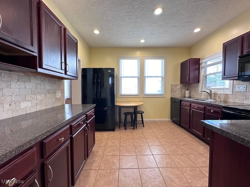 6846 Ottawa Road Cleveland, OH 44105 - Photo 23 of 50 Kitchen featuring dark countertops, baseboards, light tile patterned floors, black appliances, and a sink