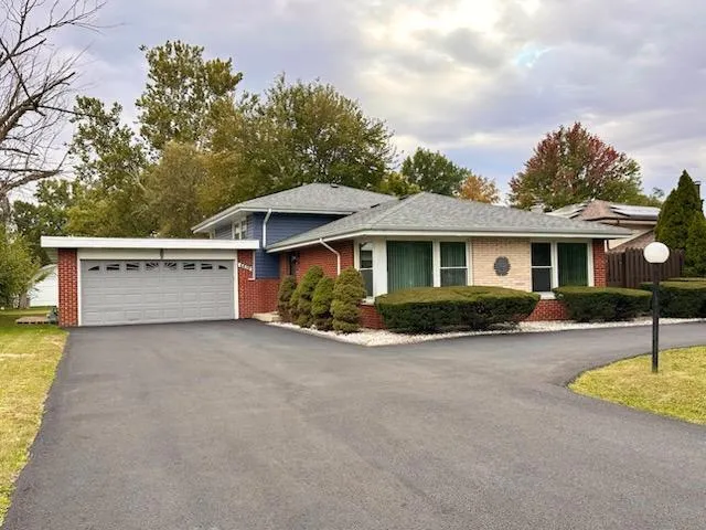 a front view of house with yard and trees in the background