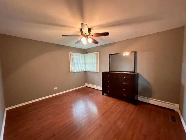 a living room with hard wood floors and a ceiling fan